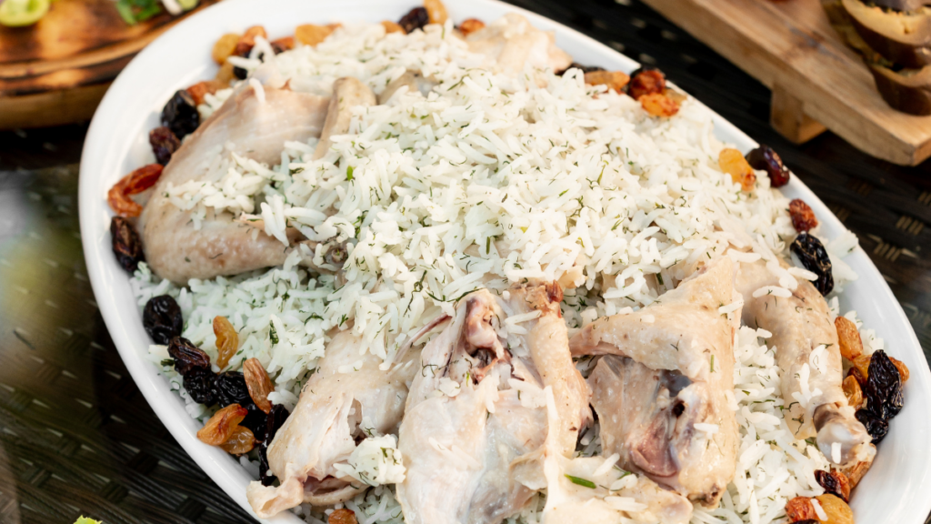 A picture of boiled rice and boiled chicken in a plate.