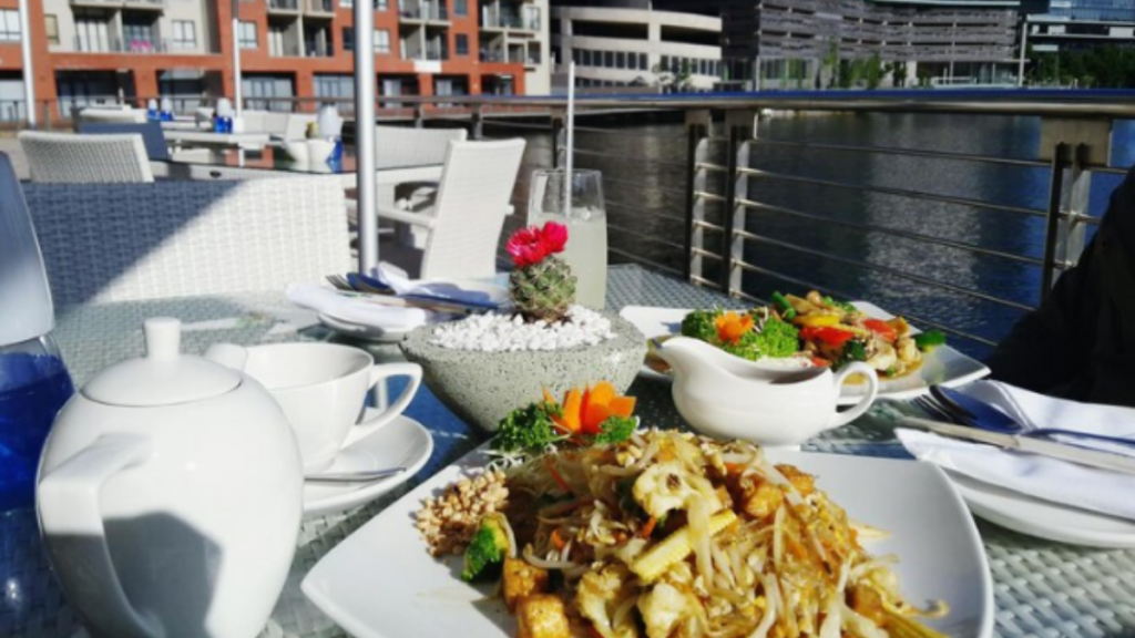 An image of a some food placed on table on a yacht floating in a lake.