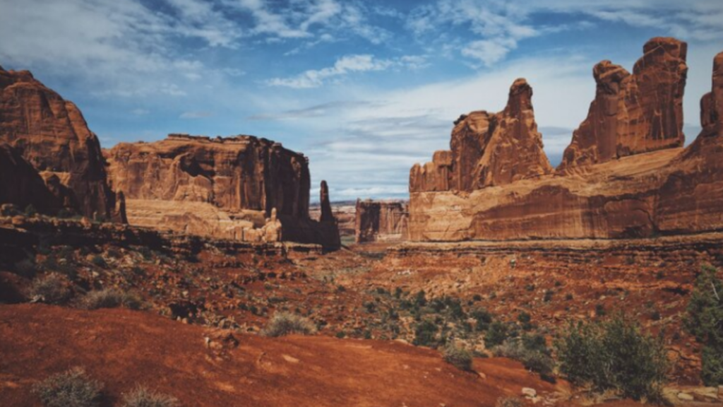 A picture of The Great Canyon with sandy mountains and desert with lots of plants on it.