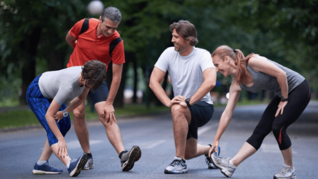 A picture of 4 people including 2 male and 2 female who are sitting after a run.