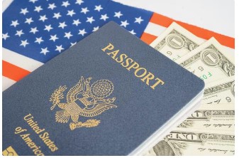 A picture of US Passport with dollor notes and US flag at the background.